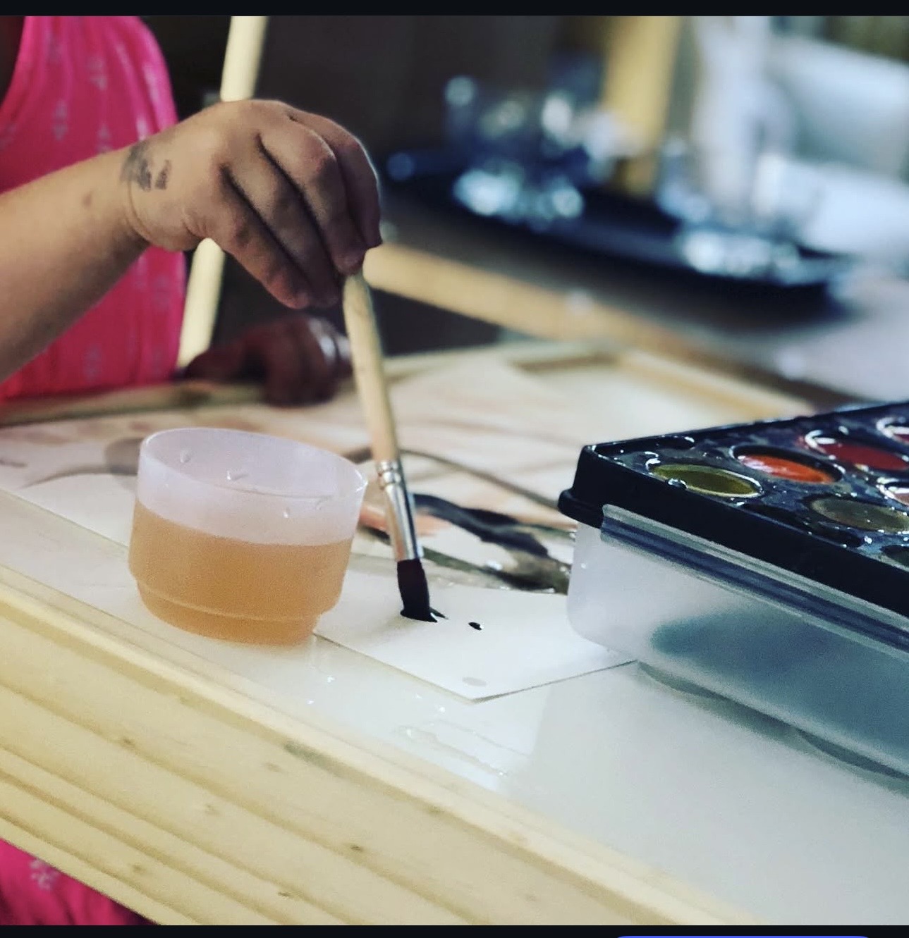 Child painting with watercolors at the table
