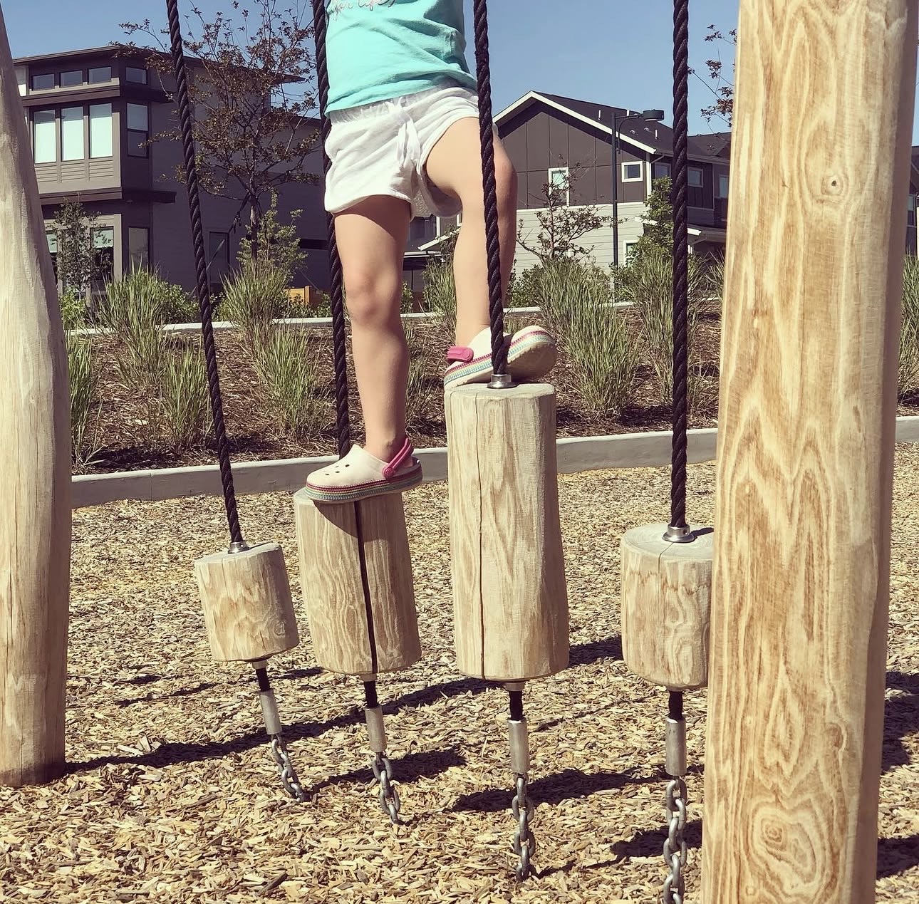 Balancing across wooden log steps at the park